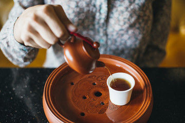 Woman pouring tea into a cup