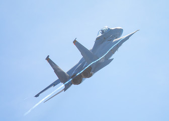 F-15 Eagle in a very close rear view, with condensation trails forming at the wing tip