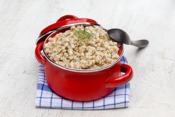 Red pan with wheat porridge - traditional meal in Ukraine, Belarus and Russia