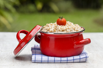 Red pan with wheat porridge - traditional meal in Ukraine, Belarus and Russia