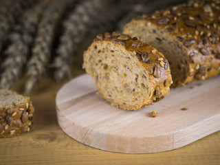 Cut into slices of baguette on a cutting Board and knife on a brown wooden table.