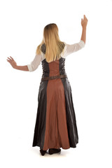 Fototapeta premium full length portrait of girl wearing brown fantasy costume.. standing pose with back to the camera on white studio background. 
