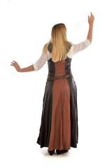 Fototapeta premium full length portrait of girl wearing brown fantasy costume.. standing pose with back to the camera on white studio background. 