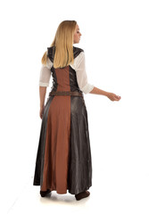 Fototapeta premium full length portrait of girl wearing brown fantasy costume, standing pose with back to the camera on white studio background. 