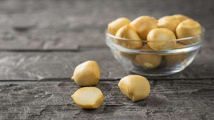 Smoked mozzarella cheese in a glass bowl on a wooden table. © kvladimirv