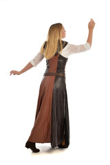 Fototapeta premium full length portrait of girl wearing brown fantasy costume, standing pose with back to the camera on white studio background. 