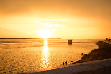 the orange sunset reflecting on the water 
