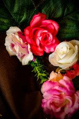 Closeup photo of the roses on the dark fabric. Floral texture and background.