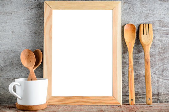 empty wooden frame and kitchen utensils on a wooden table