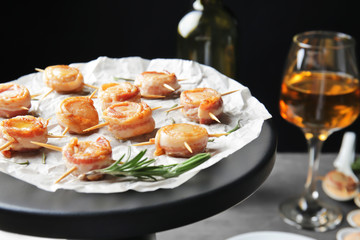 Stand with bacon wrapped scallops on table