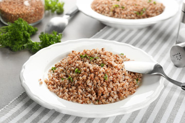 Plate of tasty buckwheat porridge on table