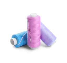 Colorful threads and needle on white background