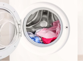 Modern washing machine with laundry, closeup