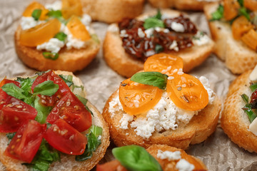 Tasty bruschettas with tomatoes on table, closeup