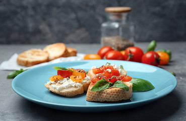 Tasty bruschettas with tomatoes on plate, closeup