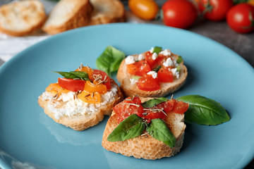 Tasty bruschettas with tomatoes on plate, closeup