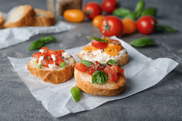 Tasty bruschettas with tomatoes on table, closeup