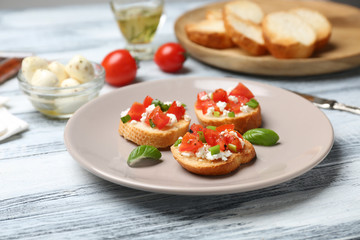 Tasty bruschettas with tomatoes on plate, closeup