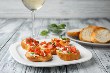 Tasty bruschettas with tomatoes on plate, closeup