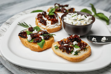 Tasty bruschettas with sun-dried tomatoes on plate, closeup