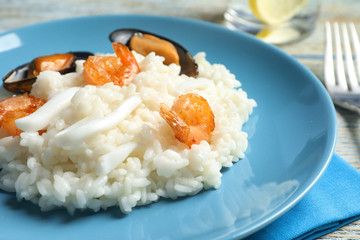 Plate with tasty seafood risotto on table
