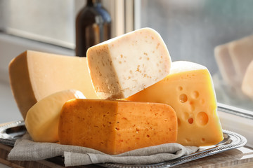 Sliced assorted cheese on windowsill
