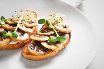 Tasty bruschettas with mushrooms on plate, closeup