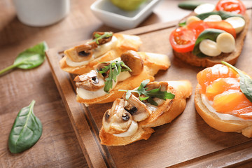 Tasty bruschettas on wooden board, closeup