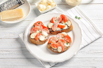 Tasty bruschettas with cherry tomatoes and cheese on plate