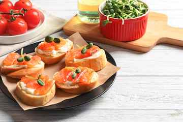 Tasty bruschettas with salmon on plate