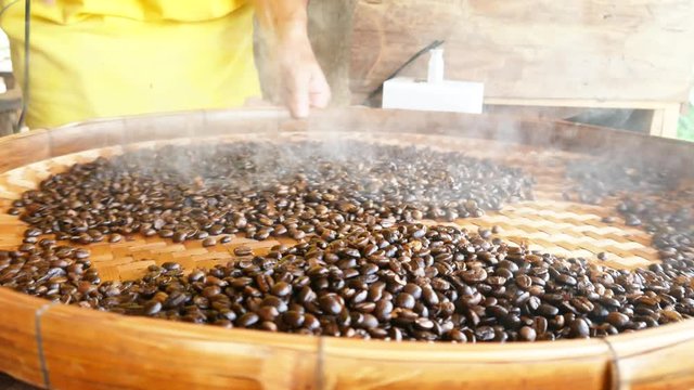Traditional roasting coffee in bowl on open fire, Thai