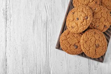 Delicious oatmeal cookies with chocolate chips on wooden board