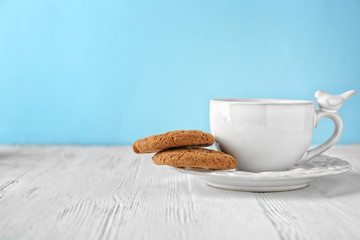 Delicious oatmeal cookies with cup on plate