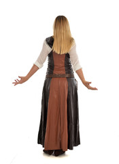 full length portrait of girl wearing brown  fantasy costume, standing pose with back to the camera on white studio background. 