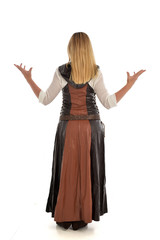 Fototapeta premium full length portrait of girl wearing brown fantasy costume, standing pose with back to the camera on white studio background. 