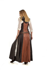Fototapeta premium full length portrait of girl wearing brown fantasy costume, standing pose with back to the camera on white studio background. 