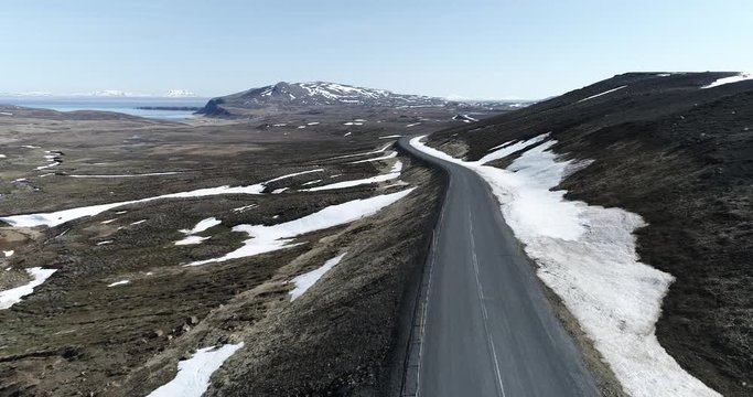 Flying backwards along Rte 85 over desolate landscape near Vidarfjall in Northeast Iceland