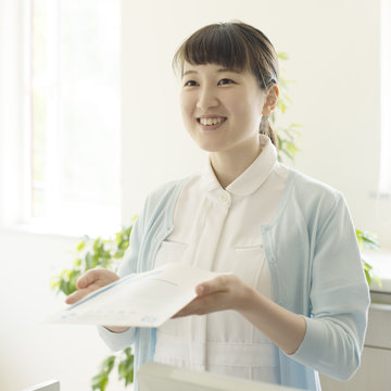 薬を持つ女性職員