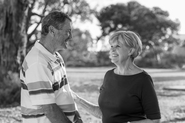 black and white portrait of American senior beautiful and happy mature couple around 70 years old showing love and affection smiling together