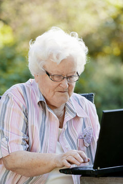 Front view of senior woman using laptop