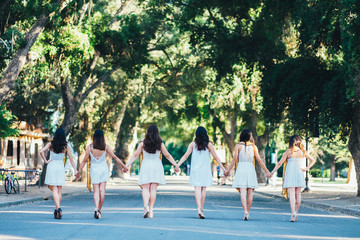 Obraz premium Girls walking graduating white dress