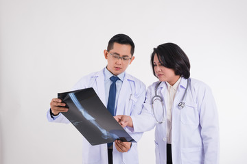 Healthcare, Orthopedic cancer and medical concept . Male and female doctors with stethoscope looking at  x-ray film of leg bone to diagnosed the pain of the patient on white background