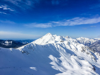 Fototapeta na wymiar Белые вершины гор и голубое небо