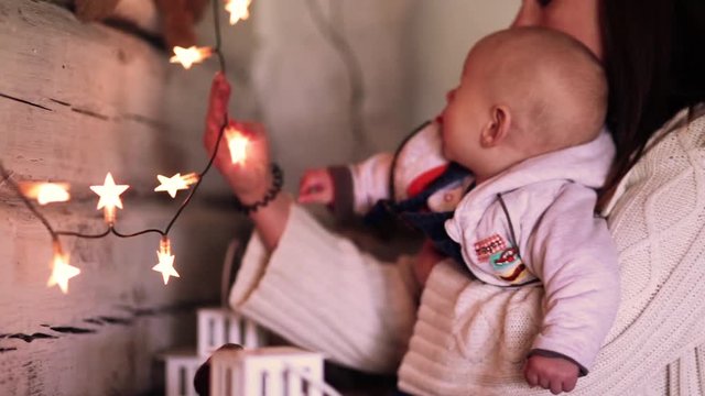 Mom shows the nursing baby a garland of stars