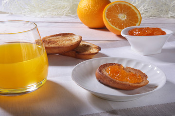 Morning Breakfast set with orange jam on bread toast and juice in glass.