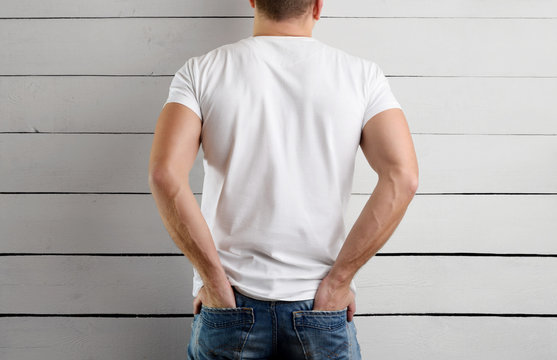 man in a white T-shirt with his hands in his jeans pockets. Mockup for clothes.
