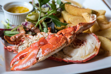 Lobster and potato chips on plate.
