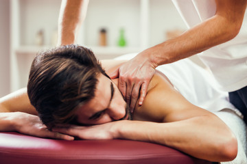 Obraz na płótnie Canvas Young man is having massage on spa treatment.