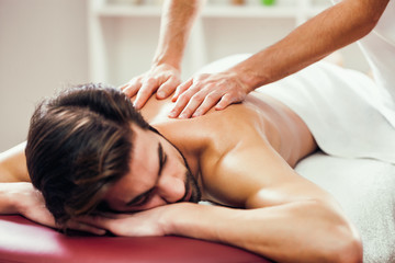 Obraz na płótnie Canvas Young man is having massage on spa treatment.
