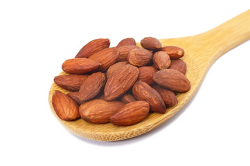 Almonds in a wooden spoon isolated on white background. Close-up.